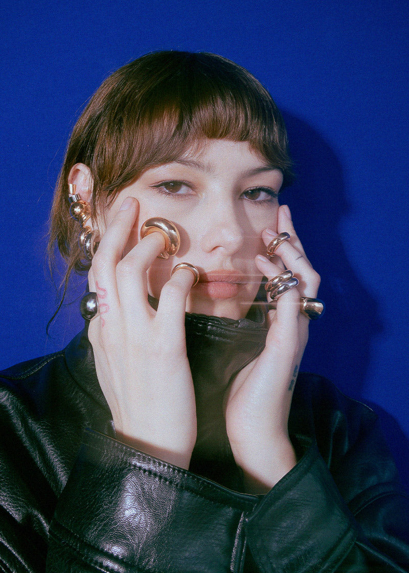 modelo con muchos aretes y anillos en acero